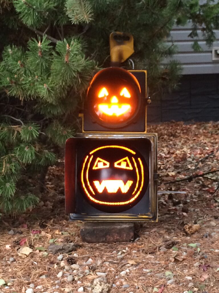 A old traffic light redesigned to house pumpkin decorations.