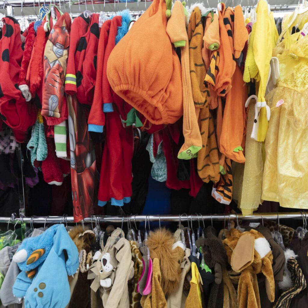 A clothing rack full of children's Halloween costumes.